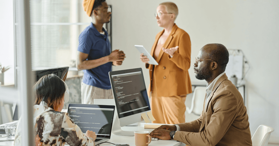 office workers in an office discussing CMS solutions