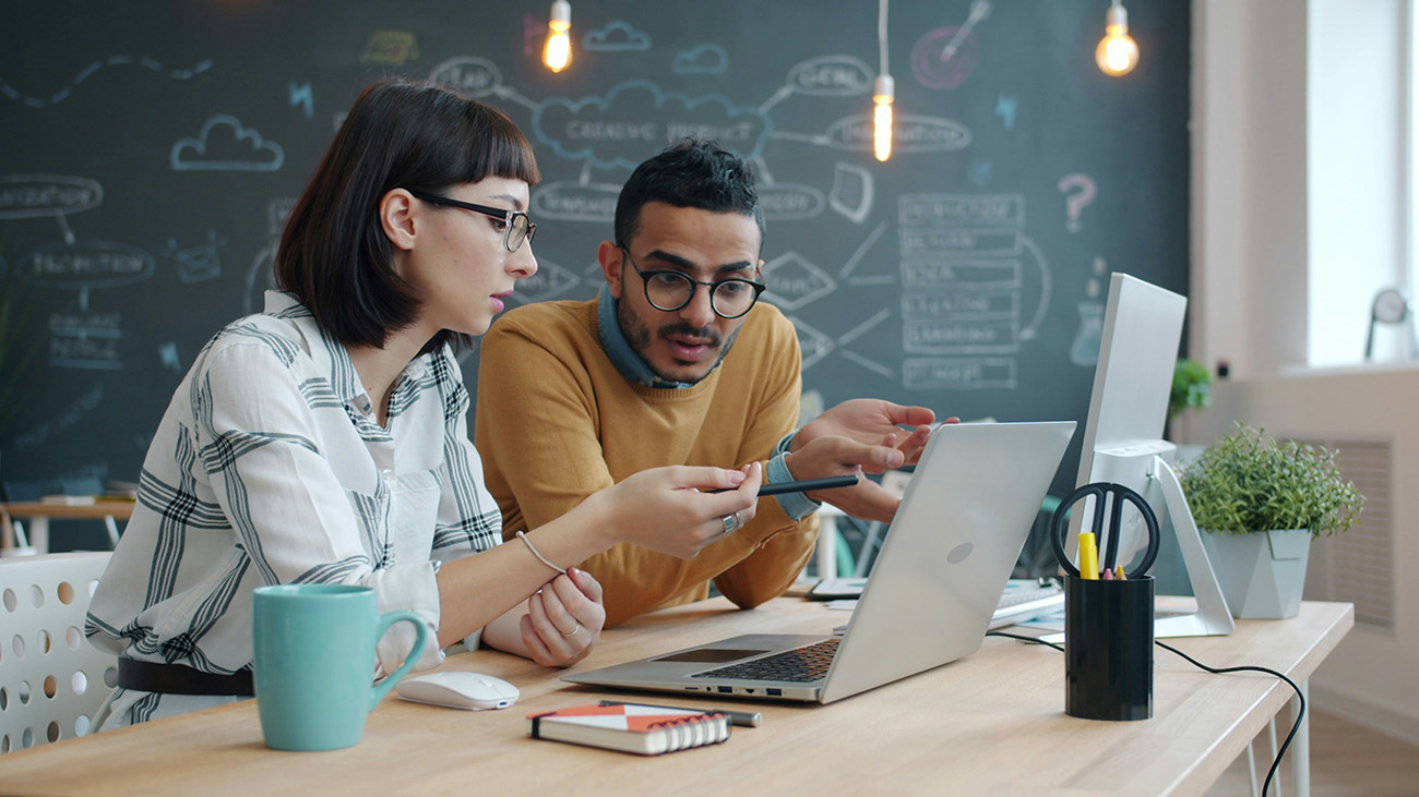 male and female software developers working together on a laptop